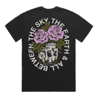 Back of a black short-sleeve t-shirt featuring a flower‚Äìskull graphic, with white text around it that reads ‚ÄúThe Sky, The Earth & All Between.‚Äù